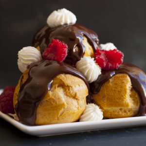 piramide di profiteroles con crema diplomatica e lamponi